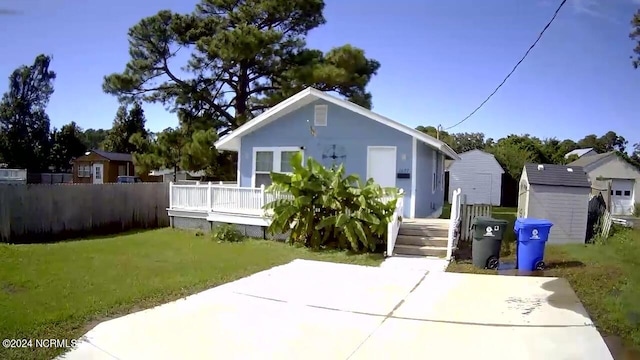 view of front of house with a front lawn and a shed