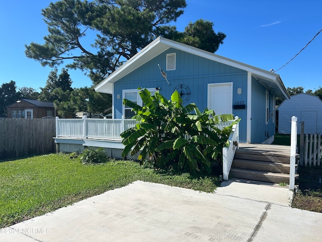 view of front of home with a front yard and a deck