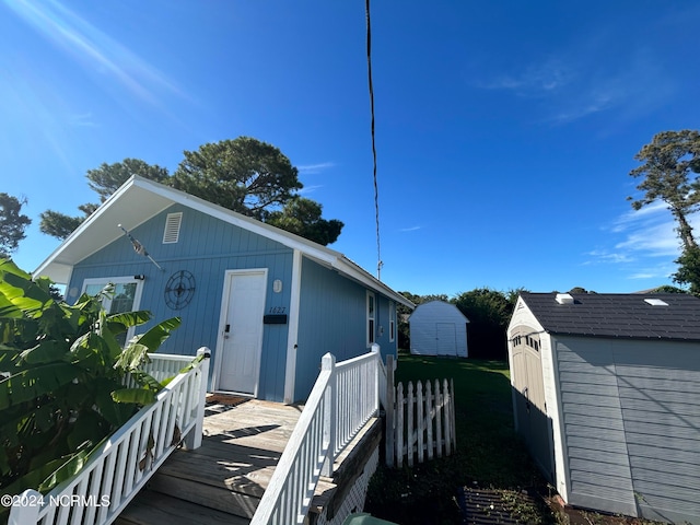 back of property with a storage shed and a deck