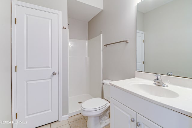 bathroom featuring tile patterned flooring, a shower, vanity, and toilet