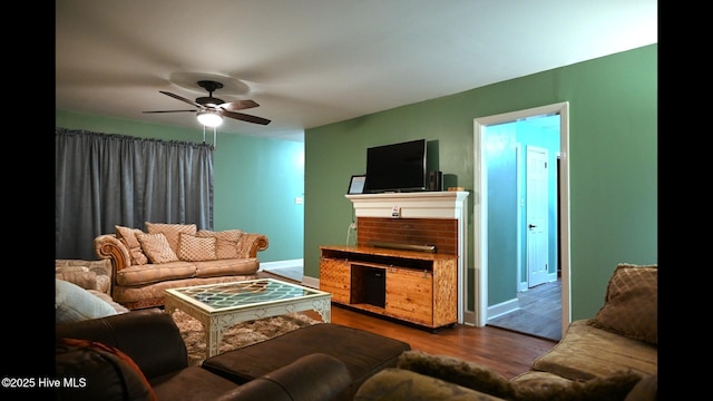 living room featuring dark wood-type flooring and ceiling fan