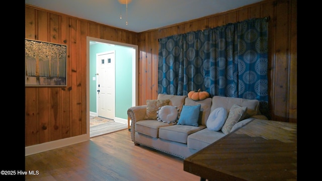 living room with light wood-type flooring and wood walls