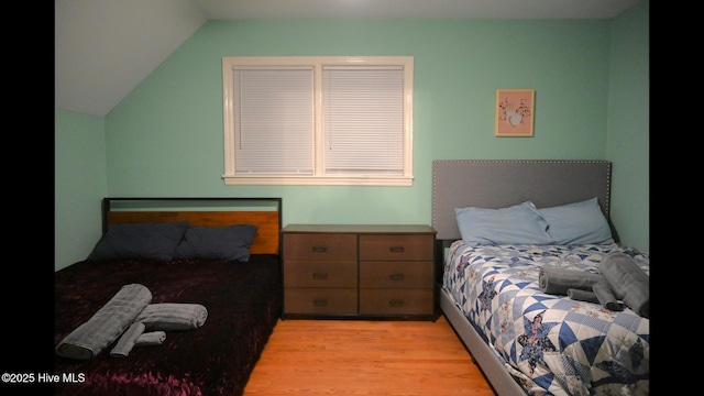 bedroom featuring vaulted ceiling and light hardwood / wood-style flooring