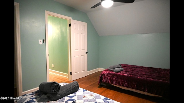 bedroom featuring hardwood / wood-style flooring, vaulted ceiling, and ceiling fan