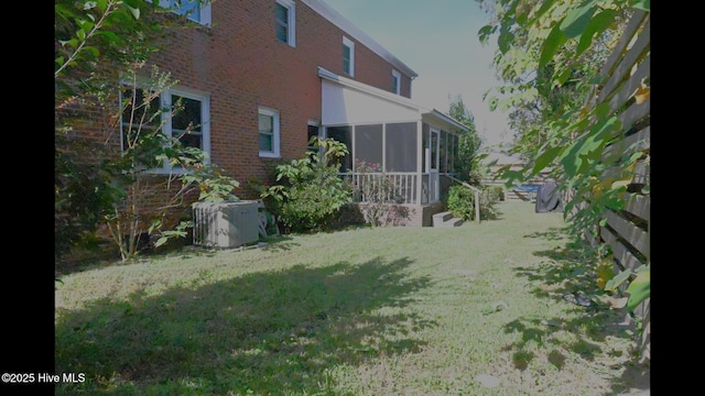 view of yard featuring central AC and a sunroom