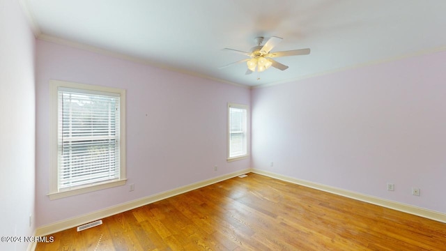 spare room featuring ceiling fan, crown molding, and wood-type flooring