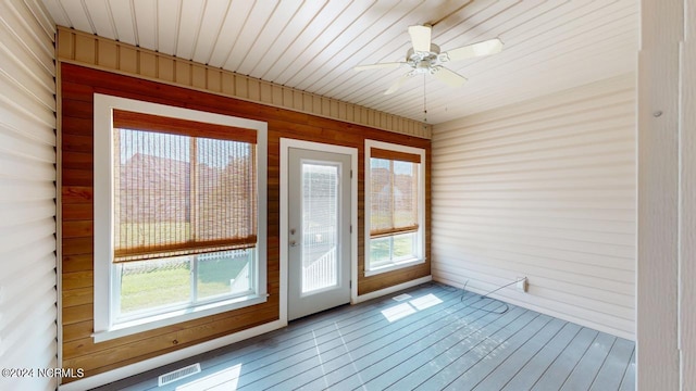 unfurnished sunroom featuring wood ceiling and ceiling fan