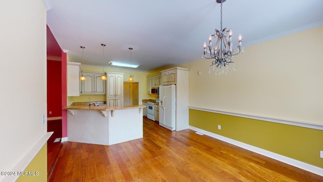 kitchen with a breakfast bar, light hardwood / wood-style floors, kitchen peninsula, white appliances, and crown molding