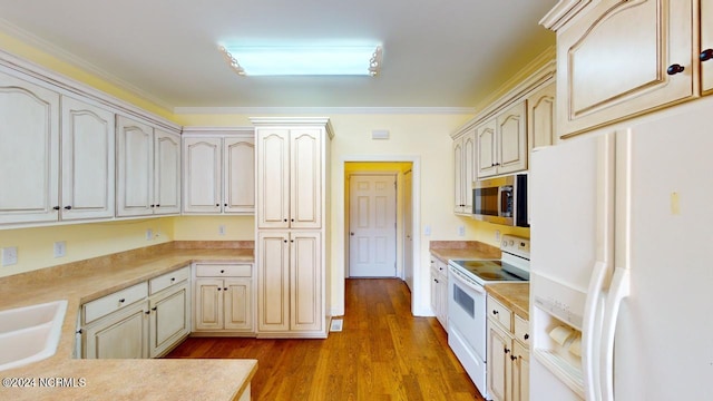 kitchen with light hardwood / wood-style floors, crown molding, white appliances, and cream cabinets