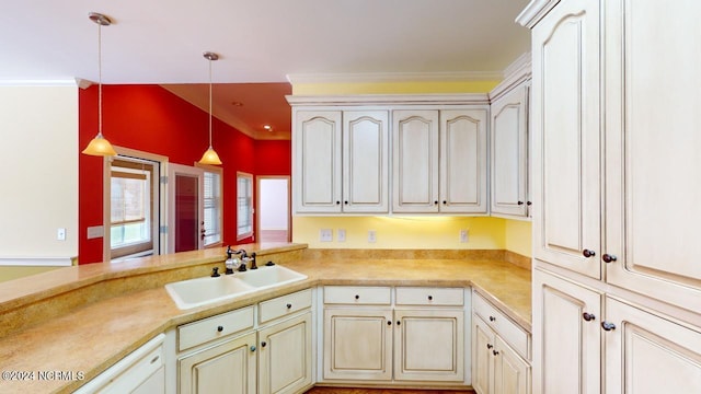 kitchen with white dishwasher, hanging light fixtures, ornamental molding, sink, and kitchen peninsula