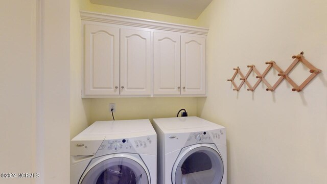 washroom featuring cabinets and washing machine and clothes dryer