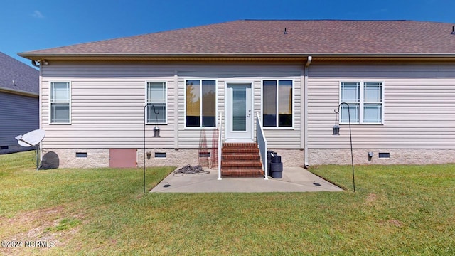 back of property featuring a lawn and a patio