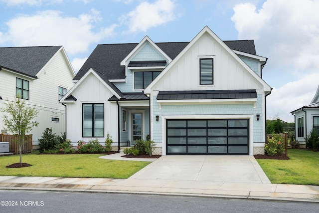 modern inspired farmhouse featuring a front yard and a garage