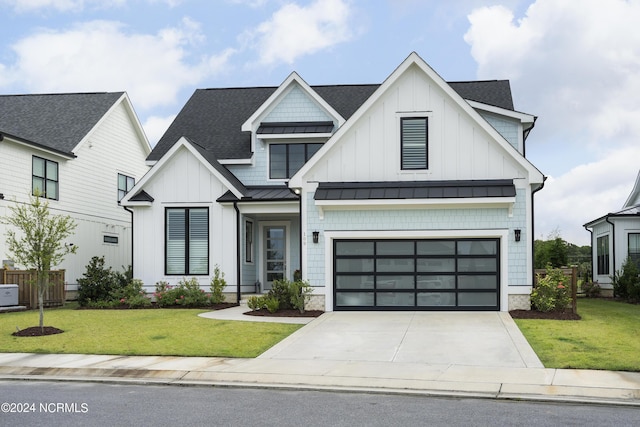 modern farmhouse style home with a standing seam roof, a front yard, board and batten siding, and driveway