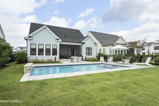 rear view of house featuring a patio, pool water feature, a lawn, and a sunroom