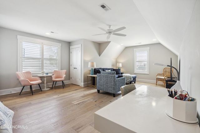 living room with ceiling fan, light wood-type flooring, and lofted ceiling