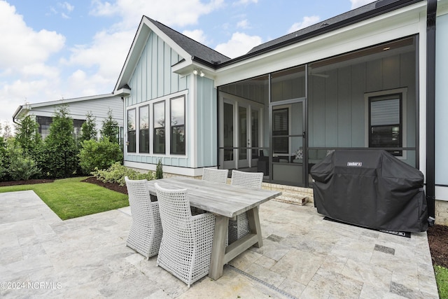 view of patio / terrace with a sunroom and a grill