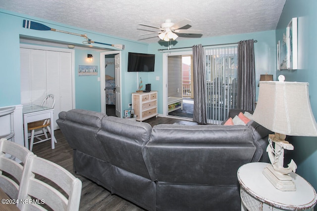 living room featuring ceiling fan, dark hardwood / wood-style floors, and a textured ceiling