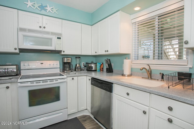 kitchen with white cabinets, white appliances, and sink