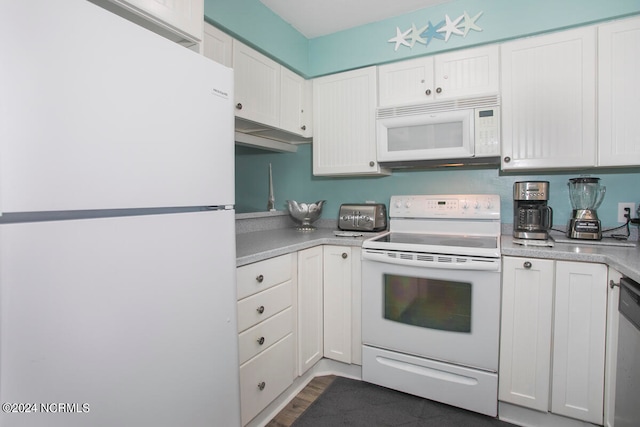 kitchen with dark hardwood / wood-style flooring, white appliances, and white cabinetry