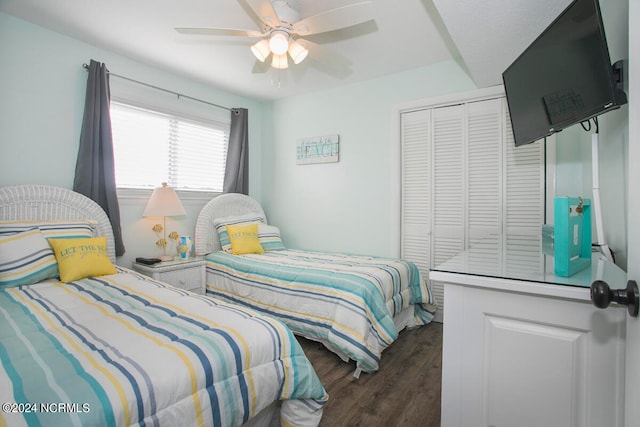 bedroom with ceiling fan, dark wood-type flooring, and a closet