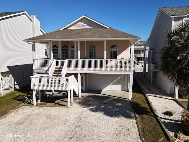 coastal home with a porch and a garage