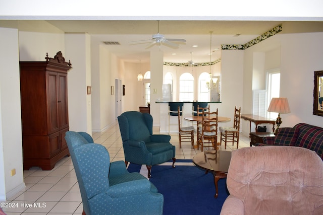 living room featuring ceiling fan with notable chandelier, a healthy amount of sunlight, and light tile patterned floors