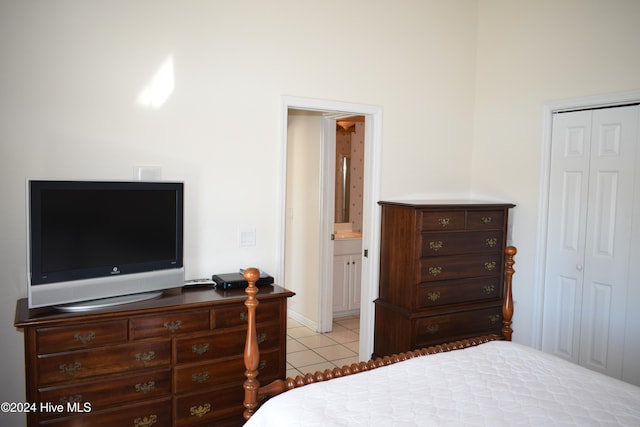 tiled bedroom featuring ensuite bath and a closet