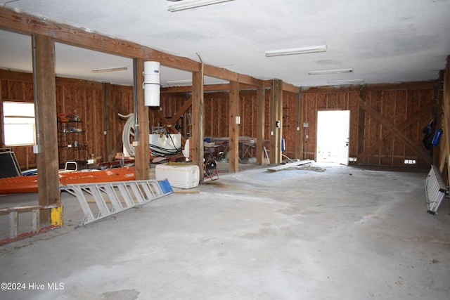 miscellaneous room with wood walls and concrete floors