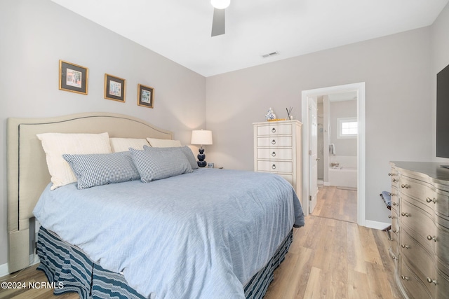 bedroom featuring connected bathroom, ceiling fan, and light wood-type flooring