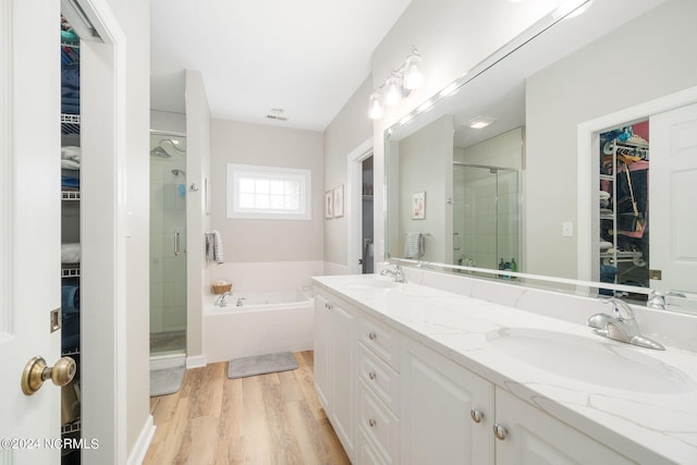 bathroom featuring independent shower and bath, vanity, and wood-type flooring