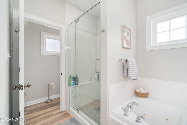 bathroom with independent shower and bath and hardwood / wood-style floors