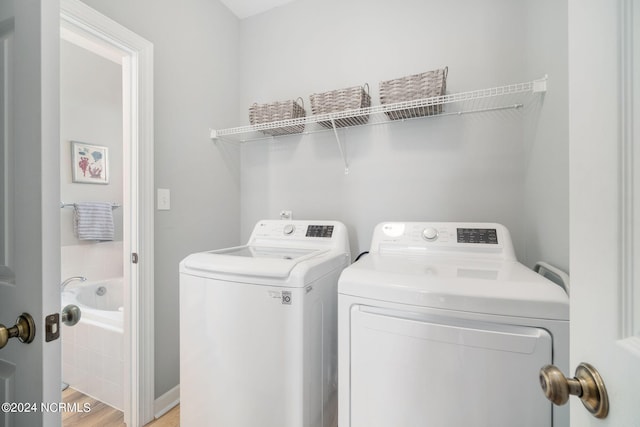 laundry room with light wood-type flooring and washer and dryer