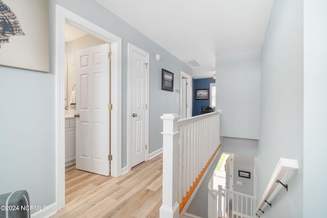 corridor with light hardwood / wood-style floors and a healthy amount of sunlight