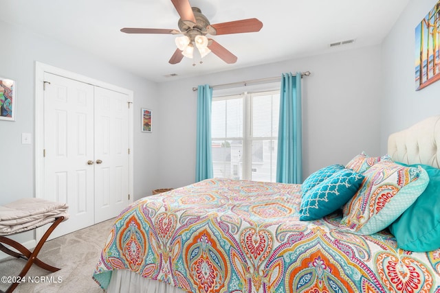 carpeted bedroom featuring ceiling fan and a closet