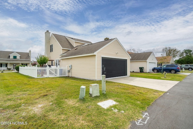 view of side of property featuring a garage, a lawn, and an outbuilding