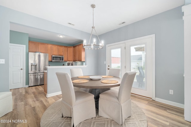 dining room featuring light hardwood / wood-style floors and an inviting chandelier