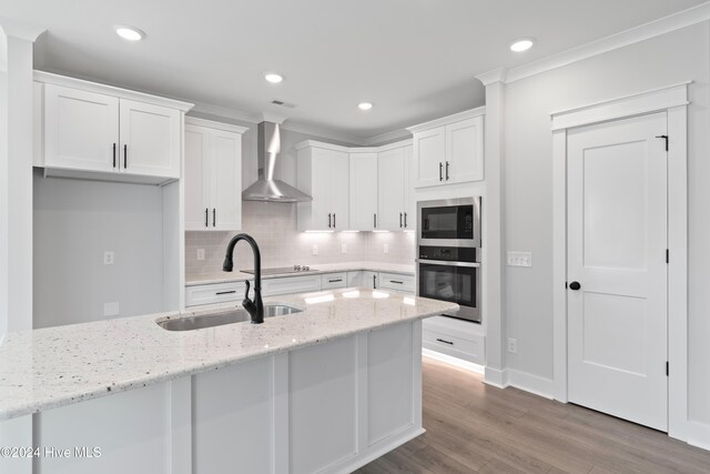 1655 Old Salt Run SW Unit L-45, Shallotte, NC 28470 - kitchen featuring stainless steel appliances, wall chimney range hood, a sink, white cabinetry, and decorative backsplash