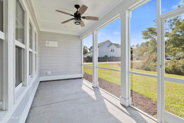 unfurnished sunroom with ceiling fan