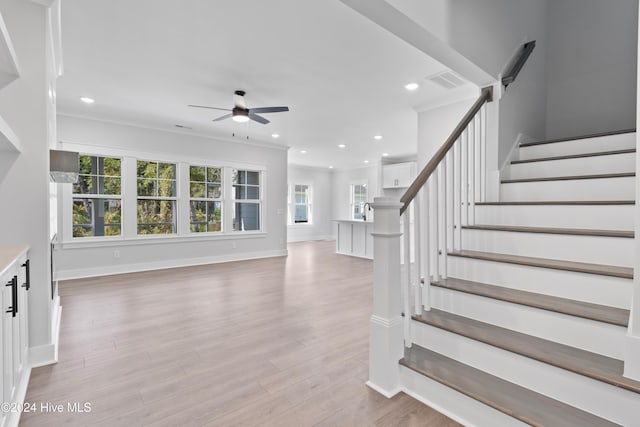 stairs featuring ceiling fan and hardwood / wood-style floors