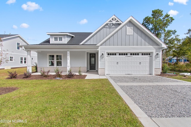 1655 Old Salt Run SW Unit L-45, Shallotte, NC 28470 - view of front facade with driveway, a garage, board and batten siding, a front lawn, and covered porch