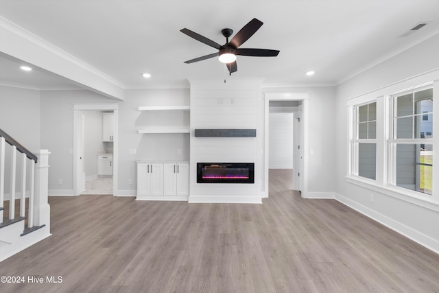 unfurnished living room with a large fireplace, light hardwood / wood-style flooring, ceiling fan, and ornamental molding