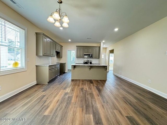 kitchen featuring decorative backsplash, a breakfast bar, dark hardwood / wood-style flooring, pendant lighting, and a chandelier