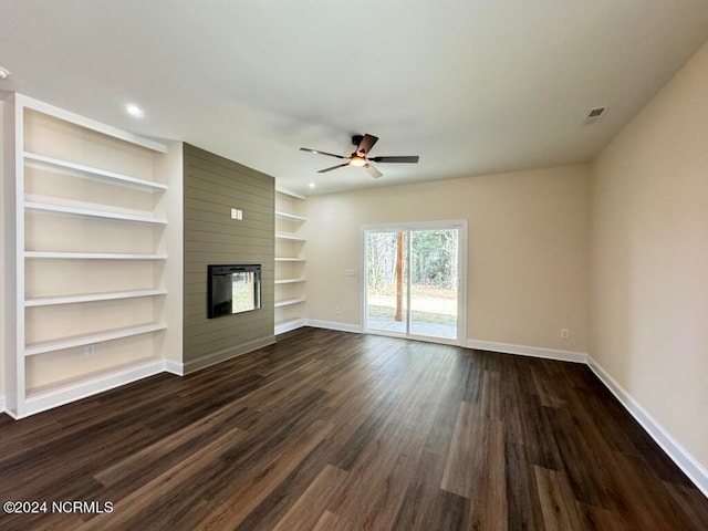 unfurnished living room featuring ceiling fan, dark hardwood / wood-style floors, a fireplace, and built in features