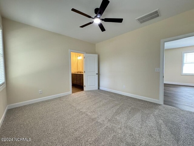 unfurnished bedroom with carpet floors, ceiling fan, and ensuite bathroom