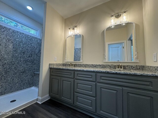 bathroom featuring walk in shower, vanity, and hardwood / wood-style floors