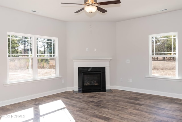 unfurnished living room featuring ceiling fan and dark hardwood / wood-style flooring