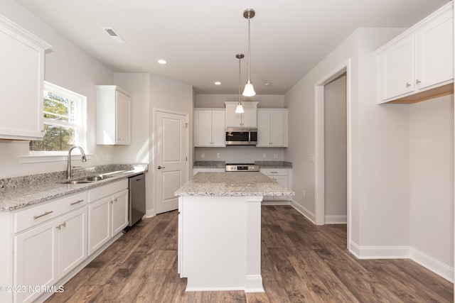 kitchen featuring white cabinets, sink, stainless steel appliances, a center island, and dark hardwood / wood-style flooring