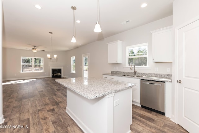 kitchen featuring a kitchen island, stainless steel dishwasher, white cabinetry, and a wealth of natural light