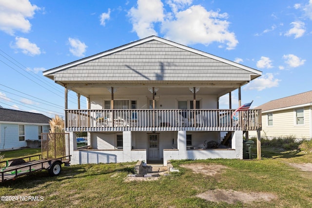 rear view of house featuring a lawn and a deck